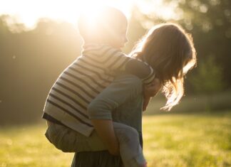 Sister giving brother a piggy back ride