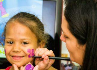 Woman painting a girl's face
