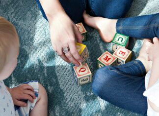 Two children and mother playing with blocks