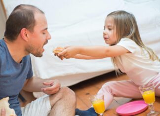Girl sharing her food with father