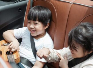 Two kids in the back seat of a car