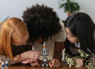 Three girls looking into a microscope