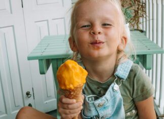 Cute Little Girl in Blue Denim Jumper Eating Ice Cream