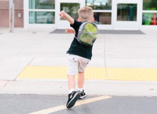 Young boy walking toward school entrance