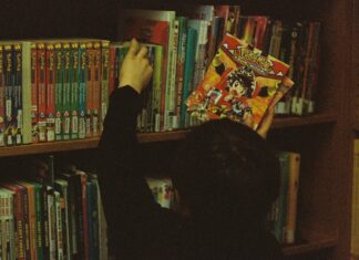 Kid pulling comic book of a shelf
