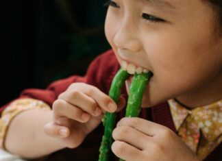 Close-Up Shot of a Child Eating Asparagus