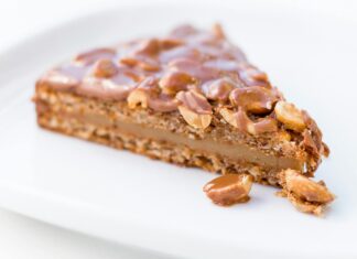 A Slice of Caramel Cake With Chocolate Coated Nuts