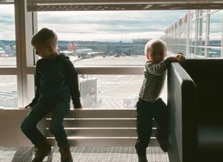 Children Playing Near Glass Panel at an airport