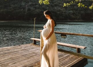 Photo Of Pregnant Woman Standing On Dock