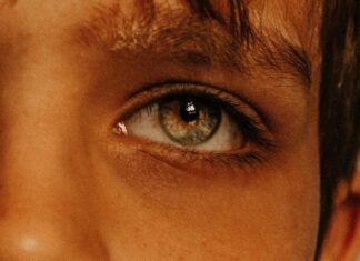 Crop pensive boy with gray green eyes