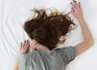 Woman lying face down in bed