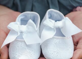 Person Carrying Pair of Baby's White Flats