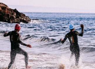 Anonymous sportspeople running into sea