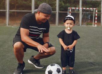 Content father teaching son to play football