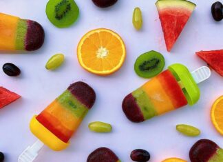 Slices of Fruits and Colorful Popsicles on White Surface