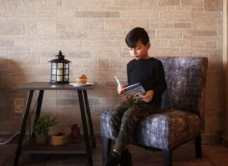 Boy Reading Book Sitting on Sofa Chair